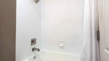 Um banheiro com banheira, chuveiro e vaso sanitário.