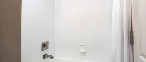 A bathroom with a bathtub, a shower, and a toilet.
