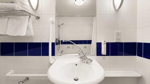 A bathroom with a white sink, a towel rack, and a shower.