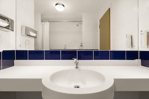 A bathroom with a white sink, a shower, and a mirror. - Days Inn by Wyndham Leicester Forest East M1 (Leicester)