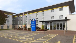 A hotel with a modern design, a Days Inn sign, and a parking area with disabled parking spaces.
