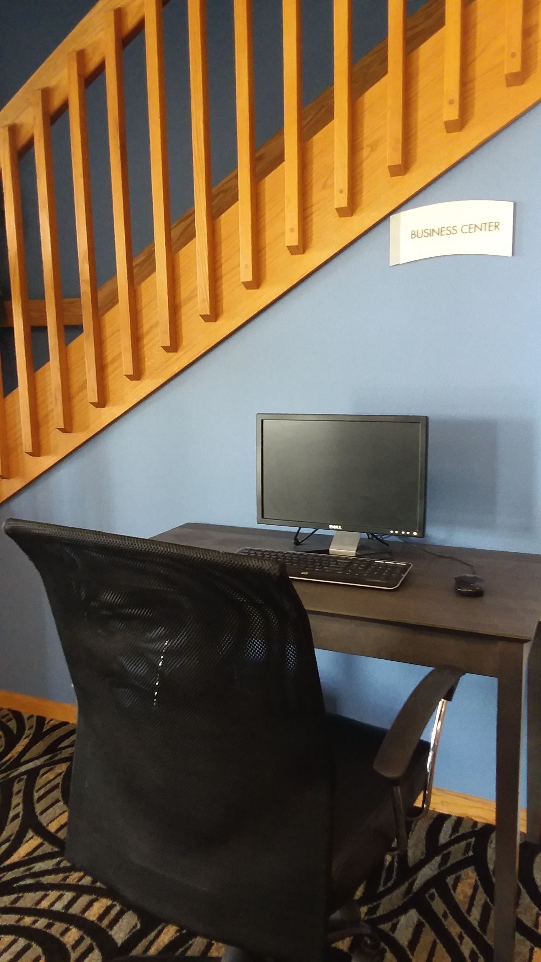 Un centro de negocios con escritorio, computadora y silla de oficina.