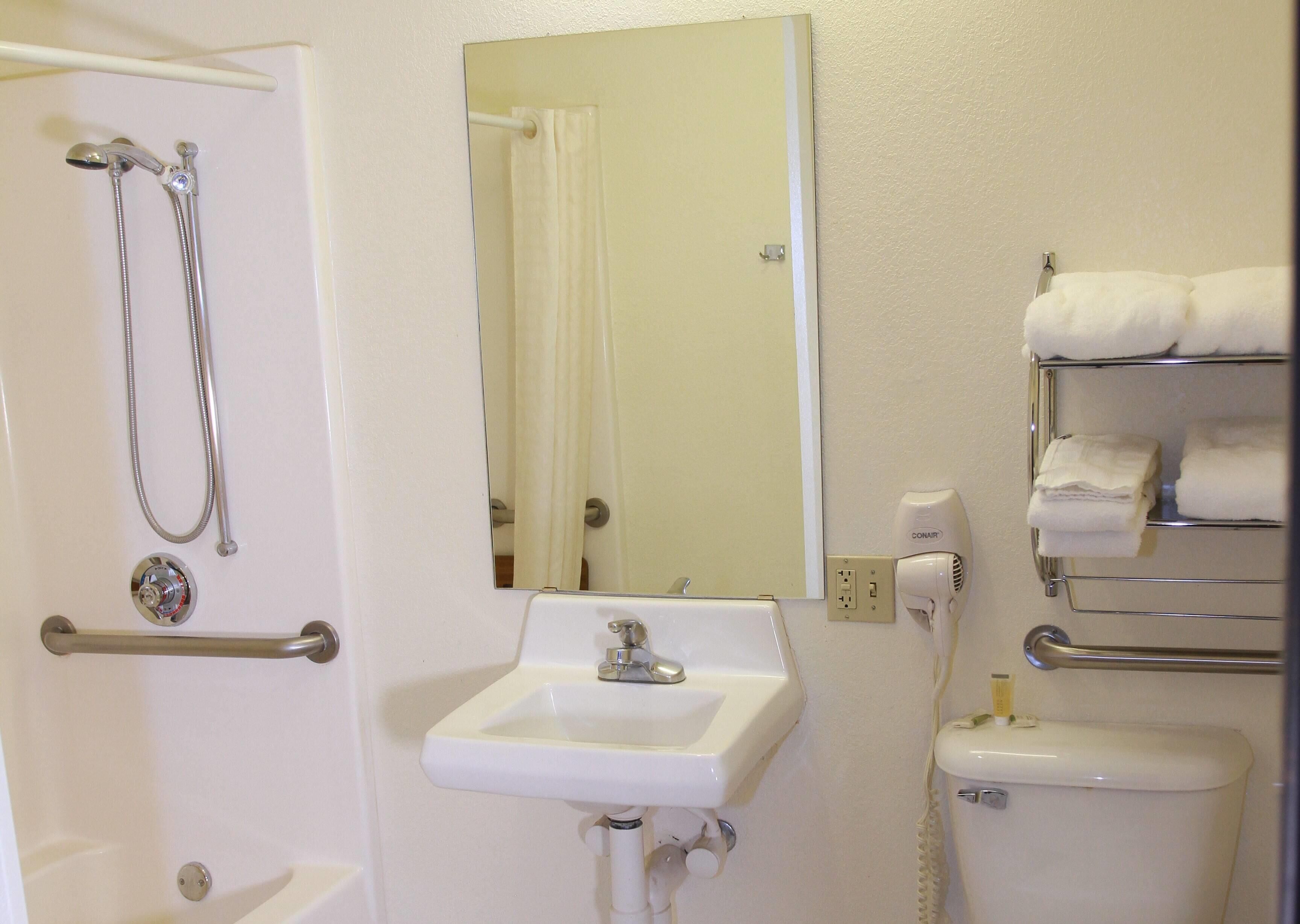 Ein Badezimmer mit Dusche, Waschbecken, Toilette und Handtuchhalter.