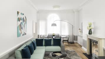 Una sala de estar moderna con un sofá modular, un comedor con mesa redonda y una chimenea.