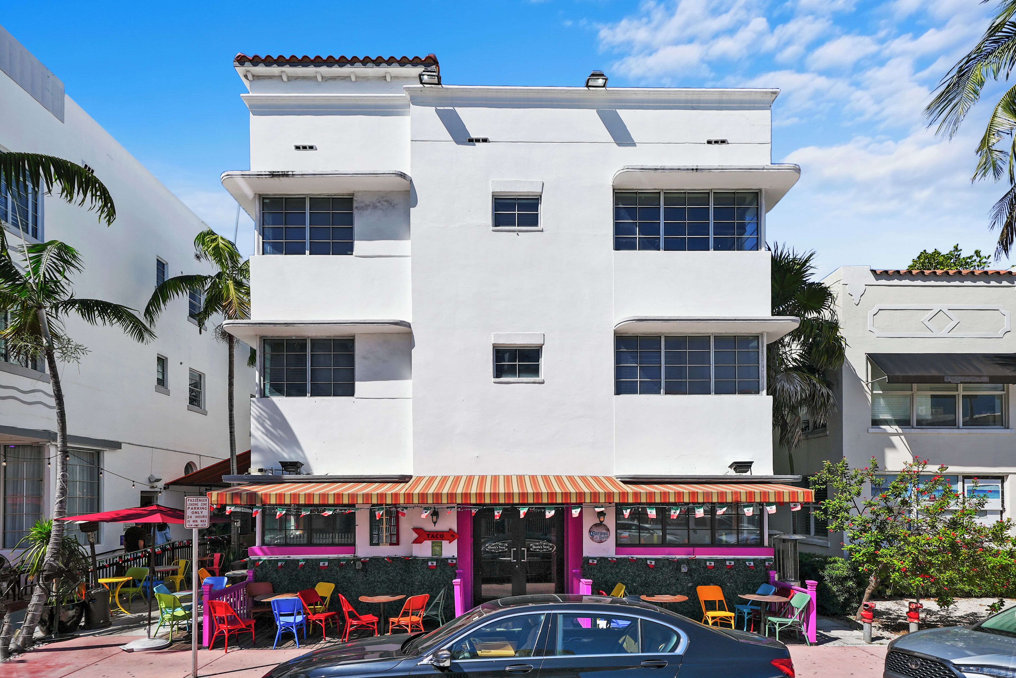 A white building with a flat roof and a red awning.