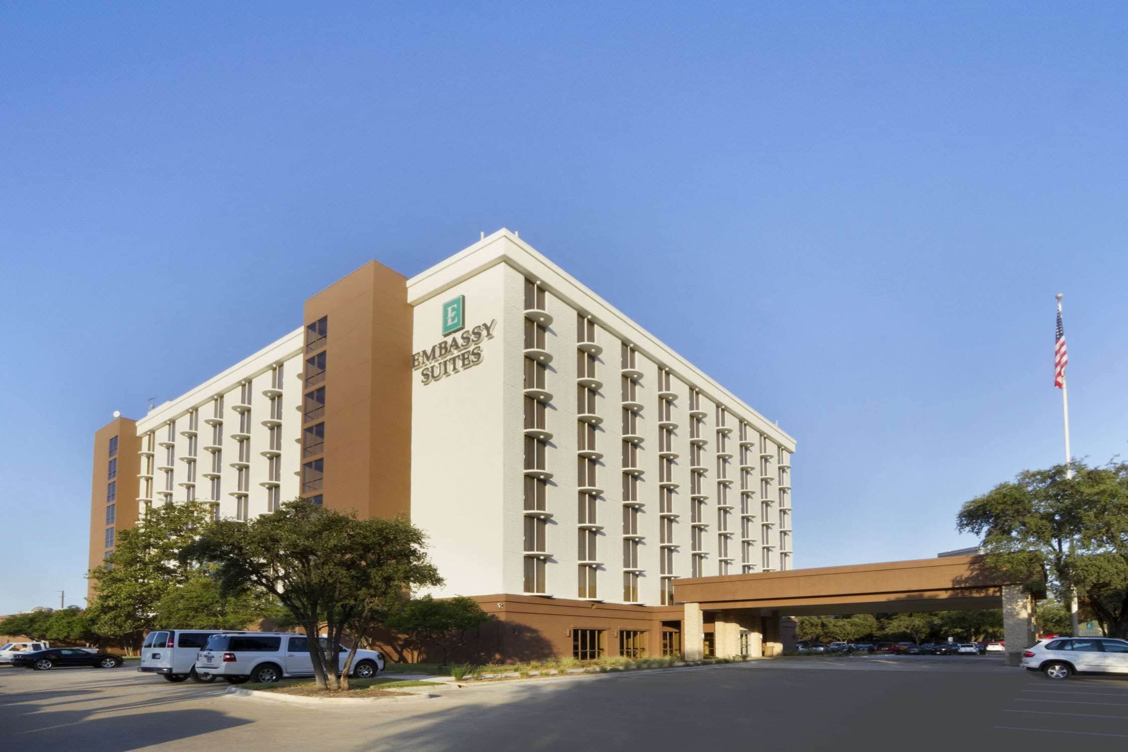 A large, multi-story building with the sign "Embassy Suites" on the facade.