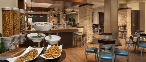 Un espace buffet proposant divers plats et une zone de restauration avec des tables et des chaises.