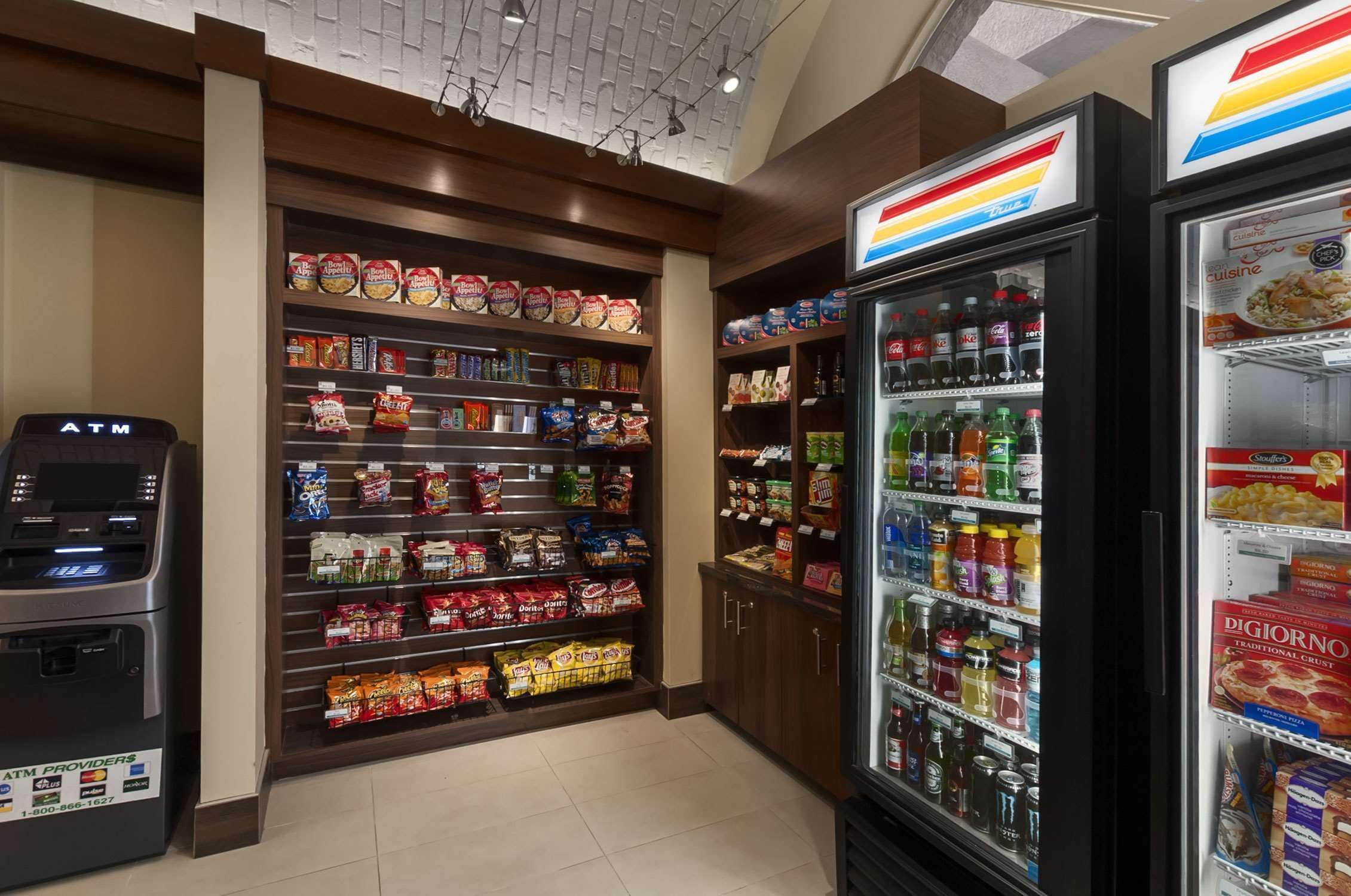 A grocery store with shelves stocked with snacks, beverages, and refrigerated items.