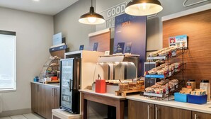 A self-service breakfast area with a refrigerator, yogurt display, and a variety of cereals and baked goods. - Holiday Inn Express Lapeer by IHG (Lapeer)
