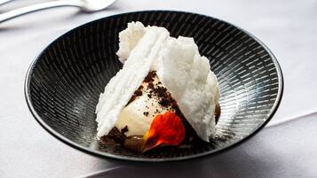 A dessert on a black plate with a textured design.