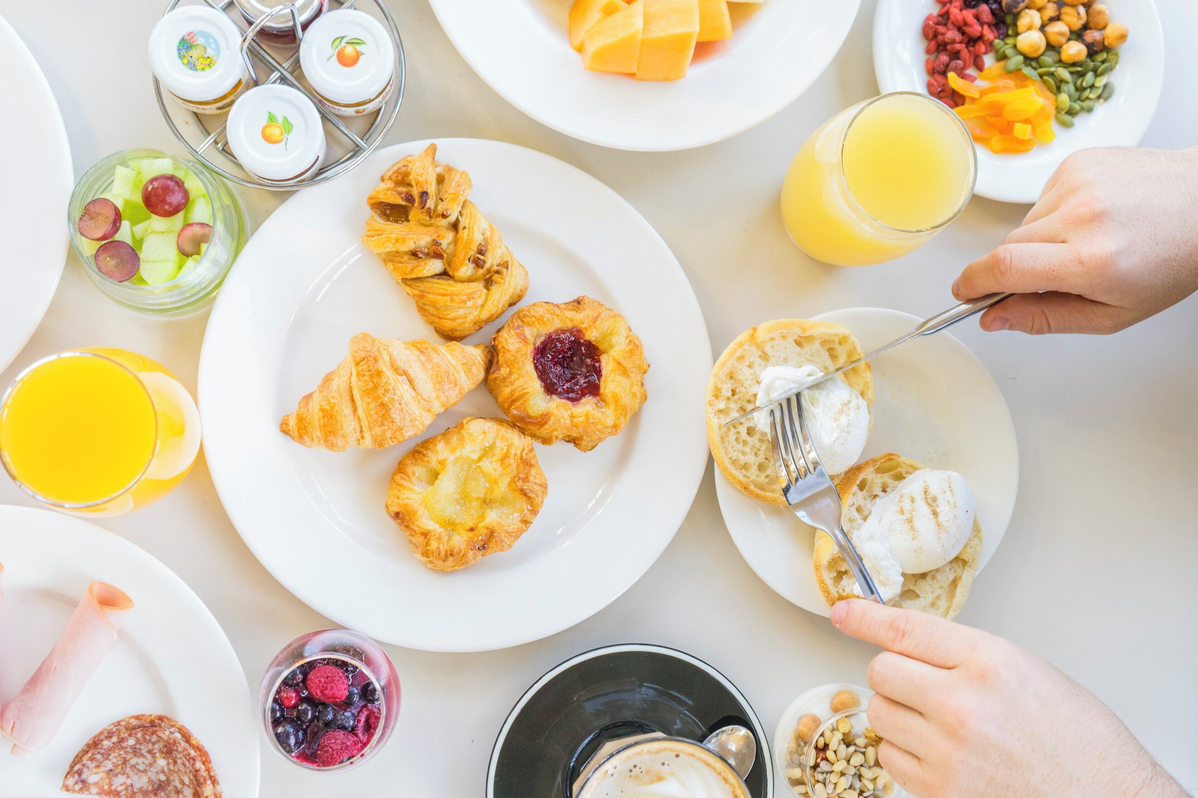 A breakfast setting with pastries, fruits, and beverages.