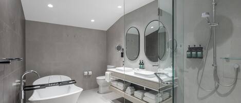 A modern bathroom with a freestanding bathtub, a glass-enclosed shower, and a vanity with a mirror.