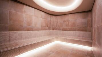 A modern, well-lit spa area with a curved bench and tiled walls.