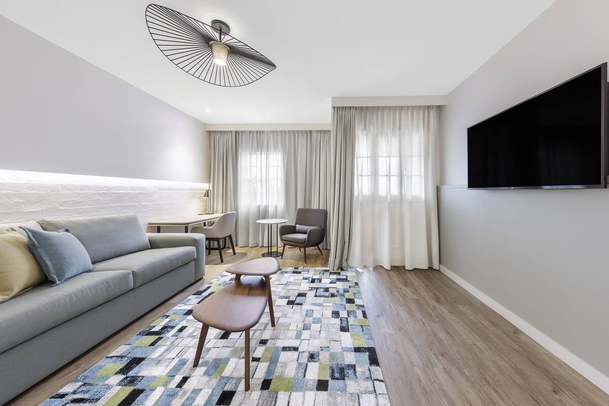 Een moderne woonkamer met een bank, salontafel en televisie.