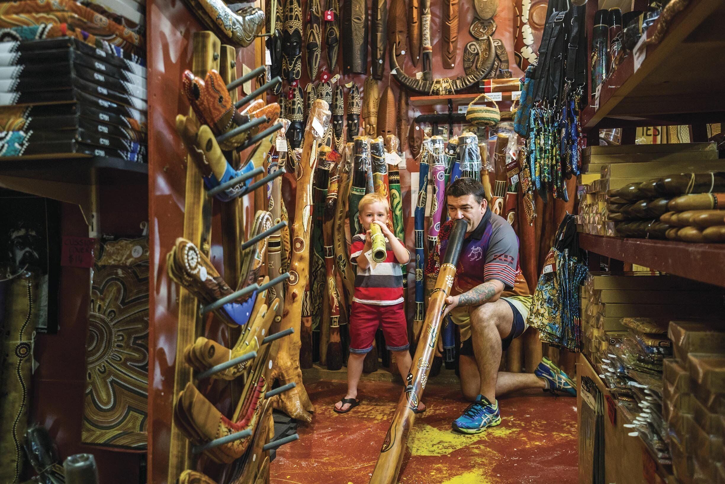 Una tienda estrecha con tallas de madera y diversos artículos exhibidos.