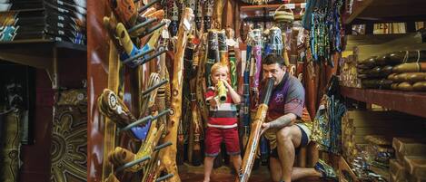 Una tienda estrecha con tallas de madera y diversos artículos exhibidos.