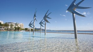 A pool with clear water, surrounded by buildings and a clear sky. - Hides Hotel Cairns (Cairns)
