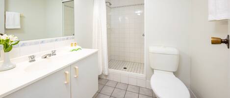 Baño con lavamanos, espejo y retrete blancos.