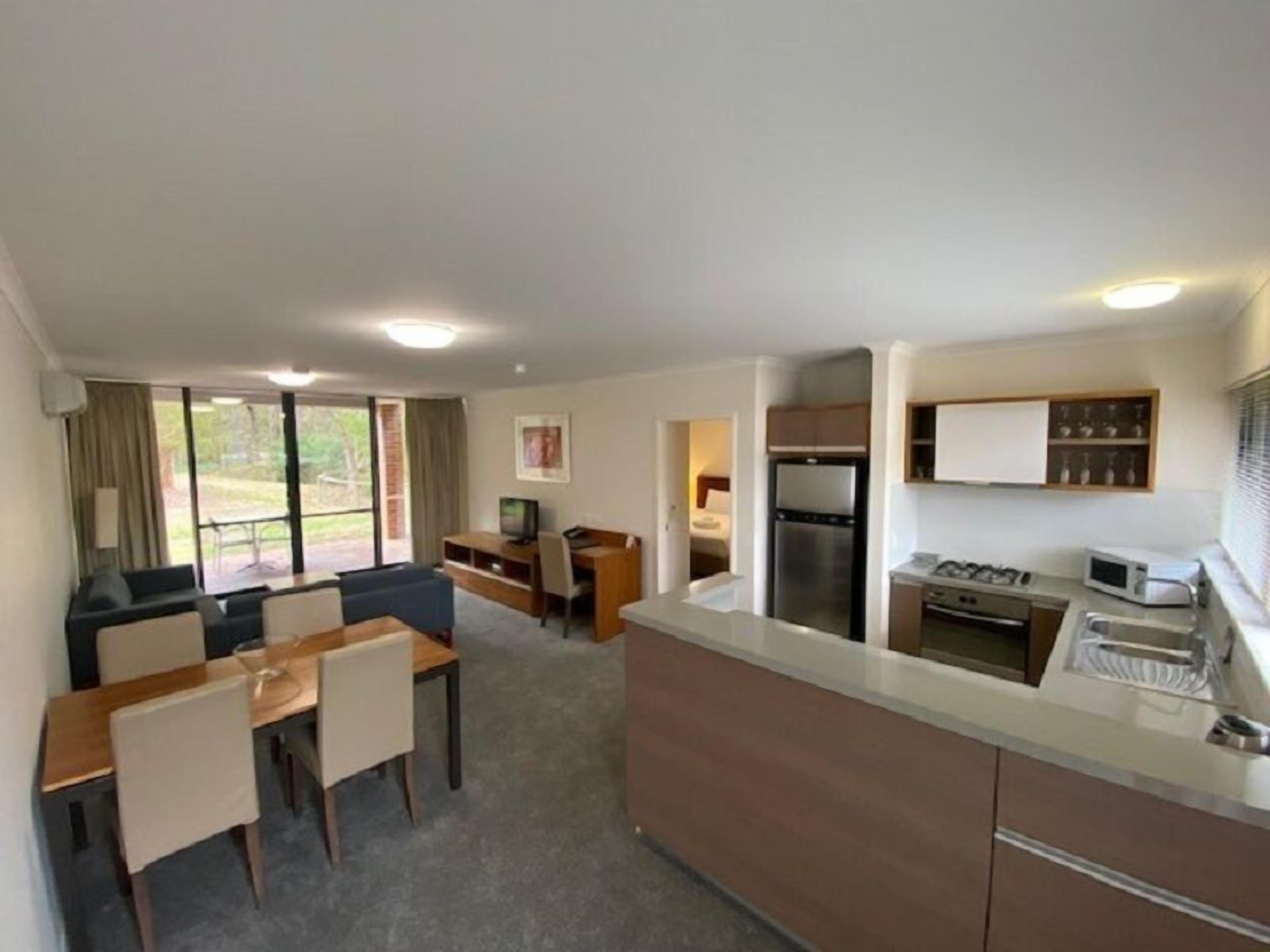 Una cocina moderna con comedor, televisión y vistas al exterior.
