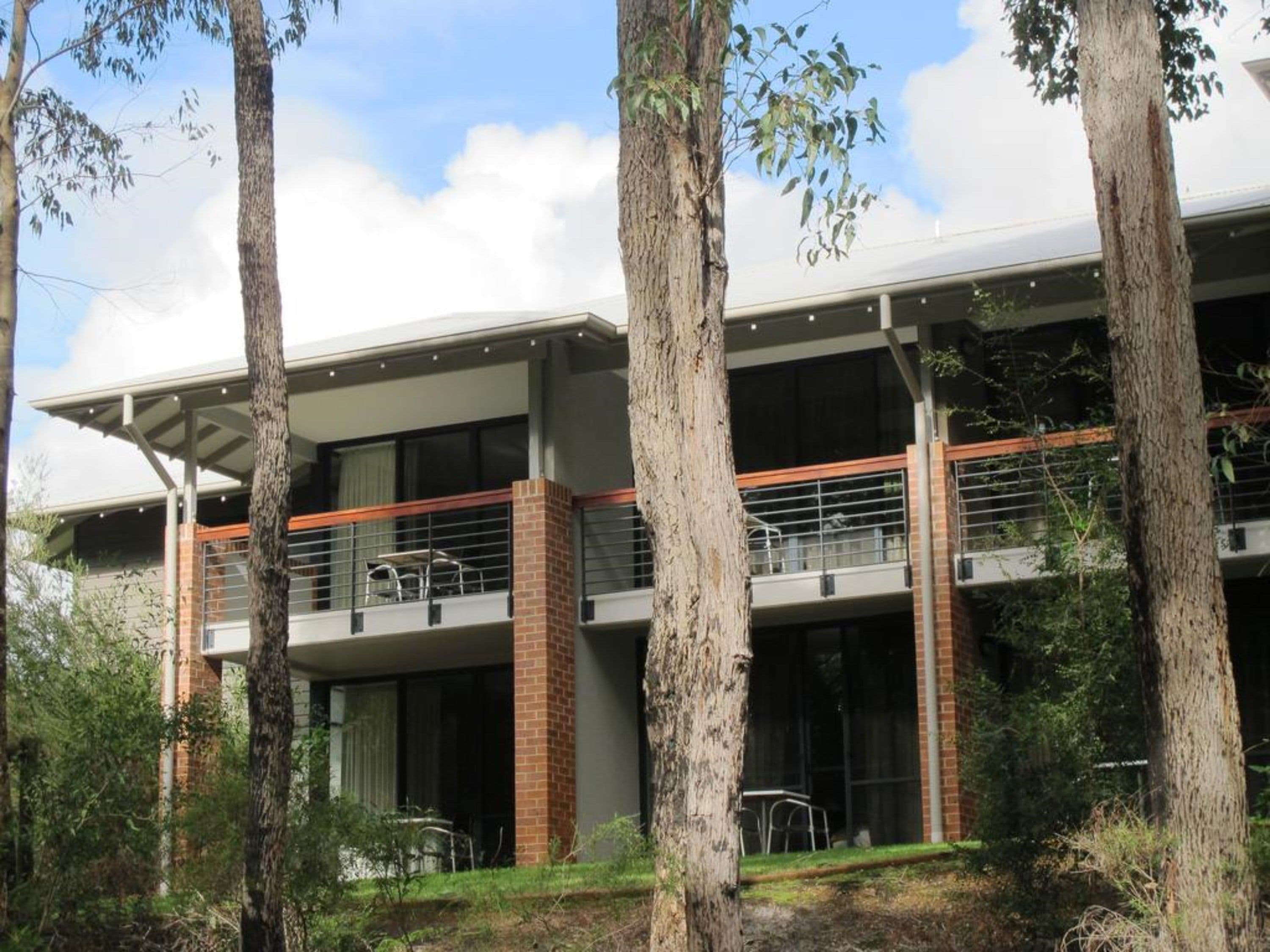A multi-story building with a modern architectural design, featuring balconies and large windows.
