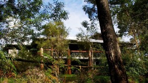A building with a modern architectural style, surrounded by dense greenery and trees. - Margarets in Town Apartments (Margaret River)