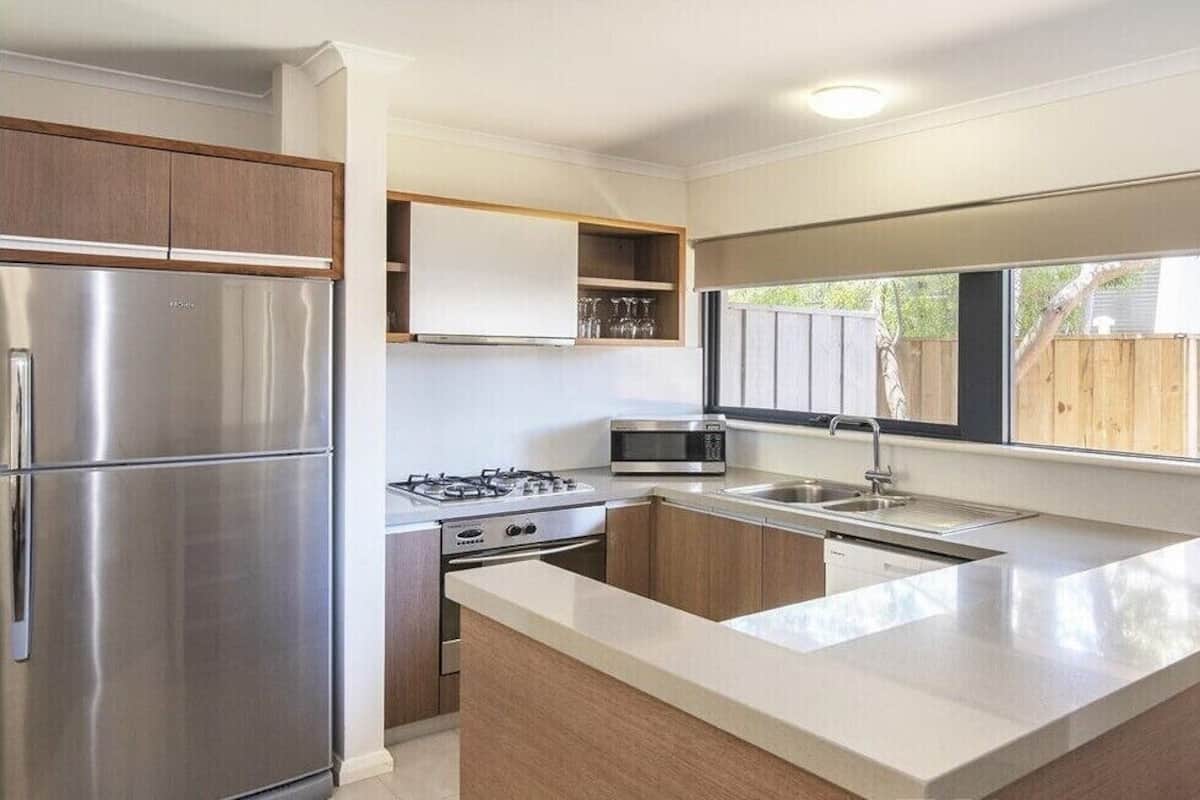A modern kitchen with stainless steel appliances, a built-in microwave, and a large island with a sink.