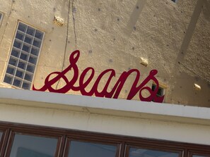 Fachada de edificio con un letrero grande y rojo que dice 'Seans'.