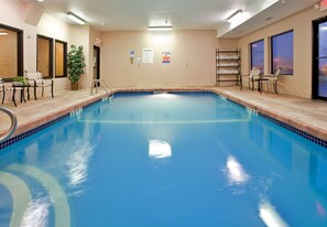Una piscina techada, sillones reclinables de piscina
