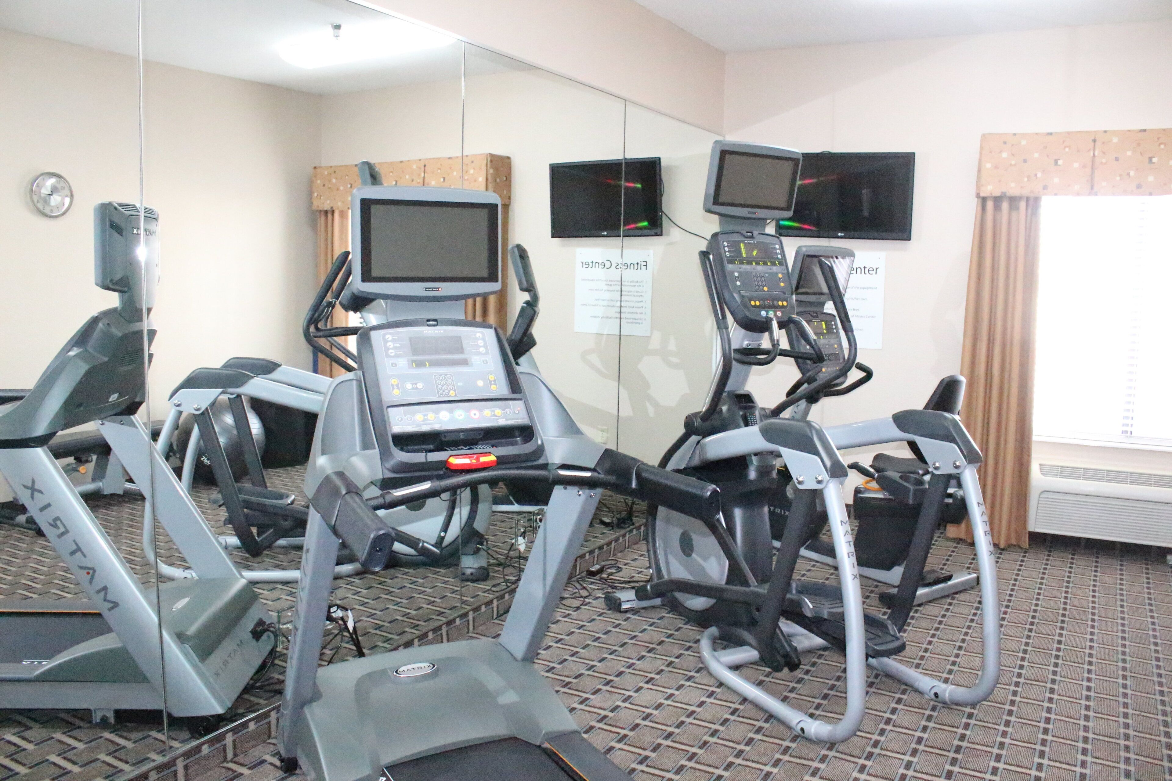 A gym with treadmills, stationary bikes, and exercise equipment.