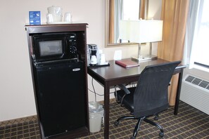 A compact hotel room with a kitchenette, including a microwave, coffee maker, and a small trash bin. - Holiday Inn Express Kansas City-Liberty by IHG (Kansas City)