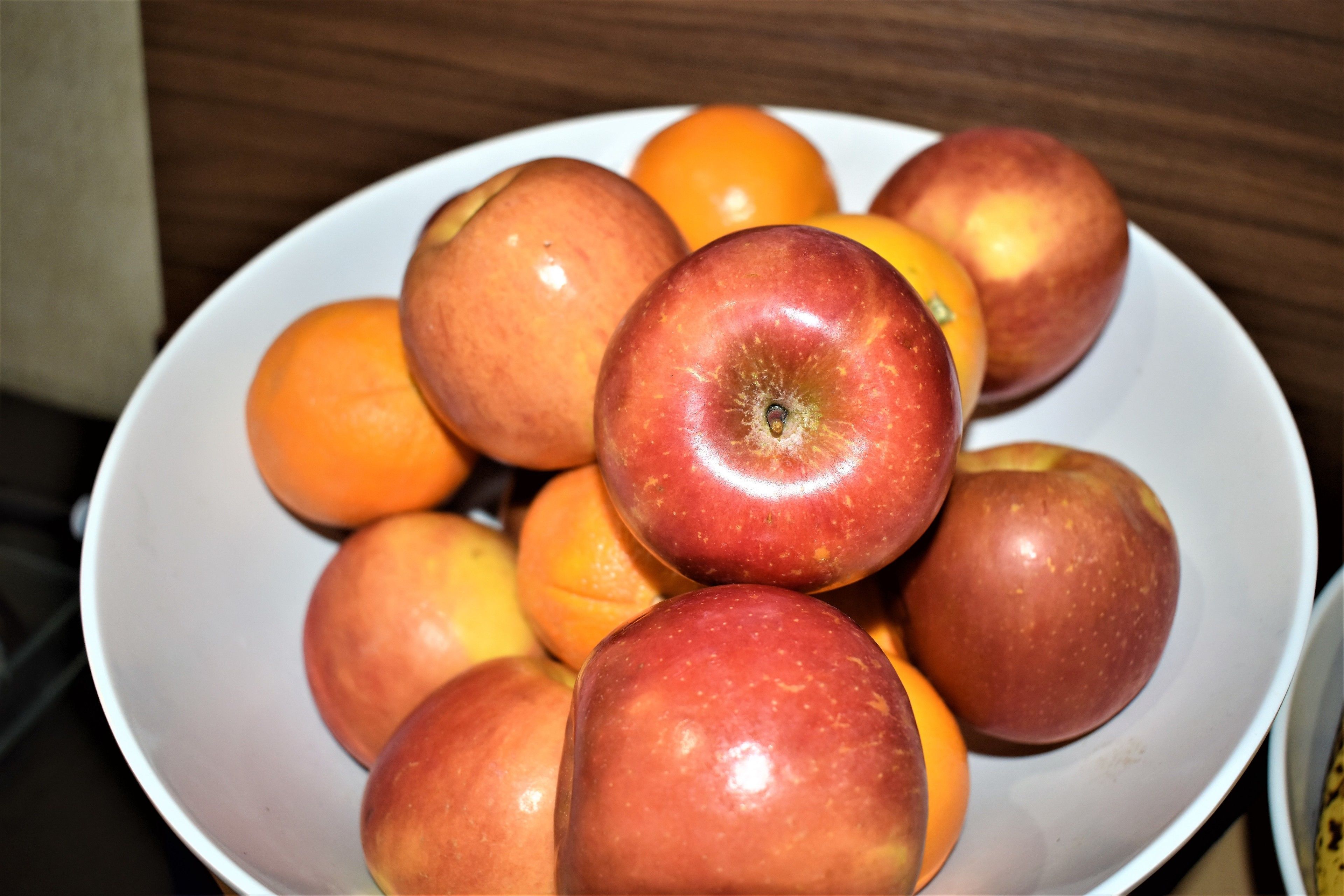 A bowl containing apples and oranges.