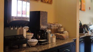 Un espace café en libre-service équipé d’une machine à café, de tasses et d’une balance pour peser le café.