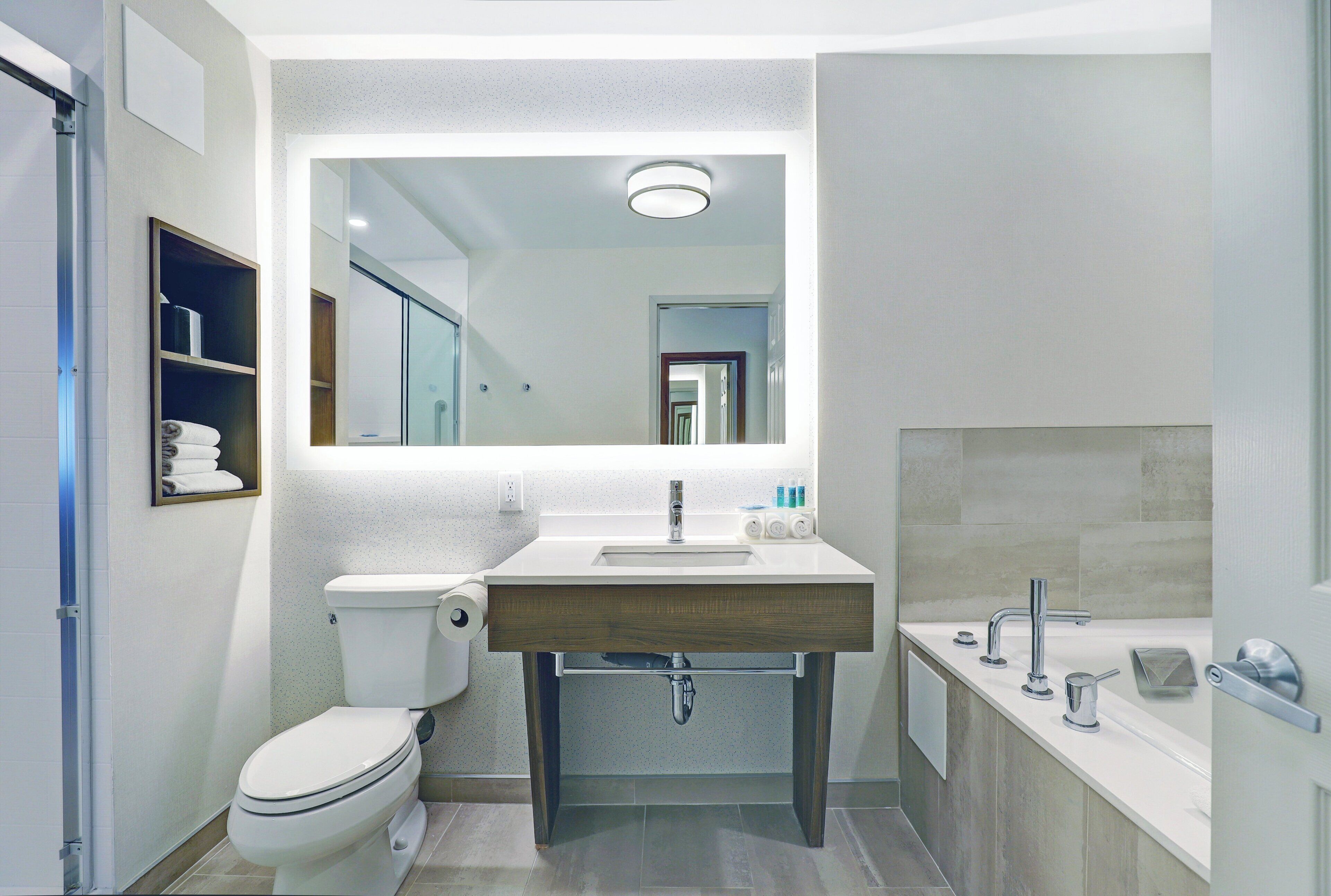 Un baño moderno con inodoro, lavabo y zona de ducha.