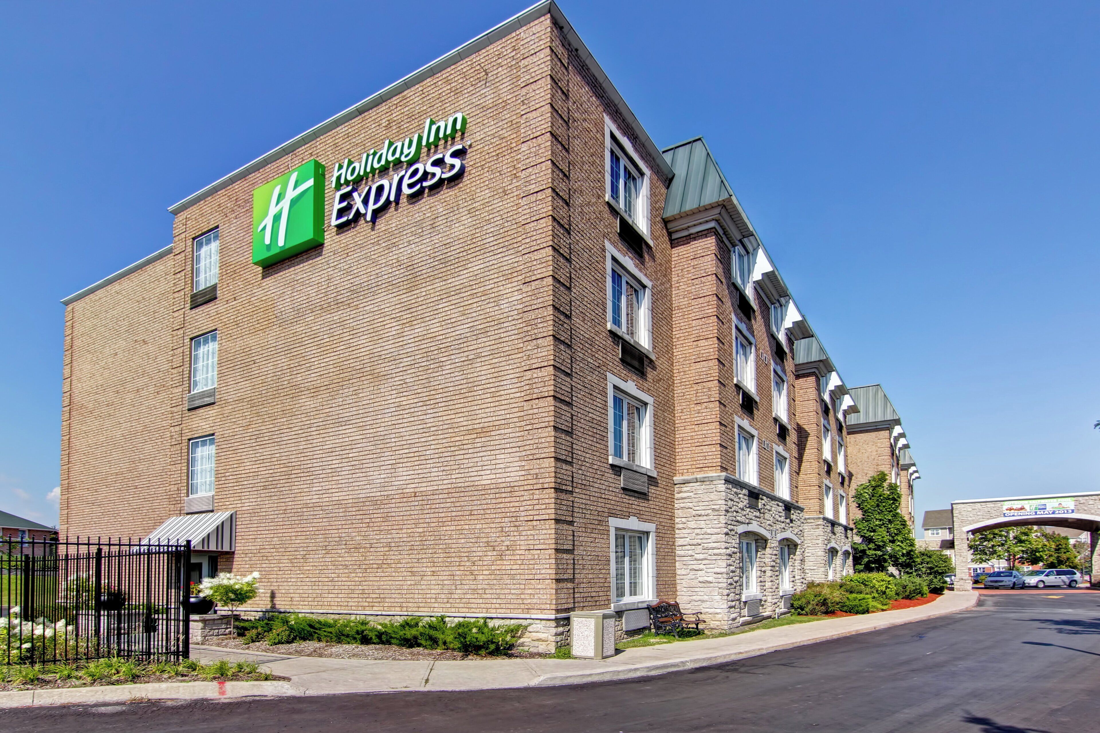 Ein Hotel Holiday Inn Express mit Ziegelaußenwand, vielen Fenstern und einem Parkplatz.
