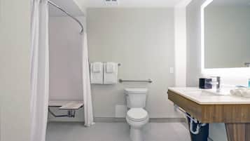 Et moderne badeværelse med bruser, toilet og vaskemøbel.