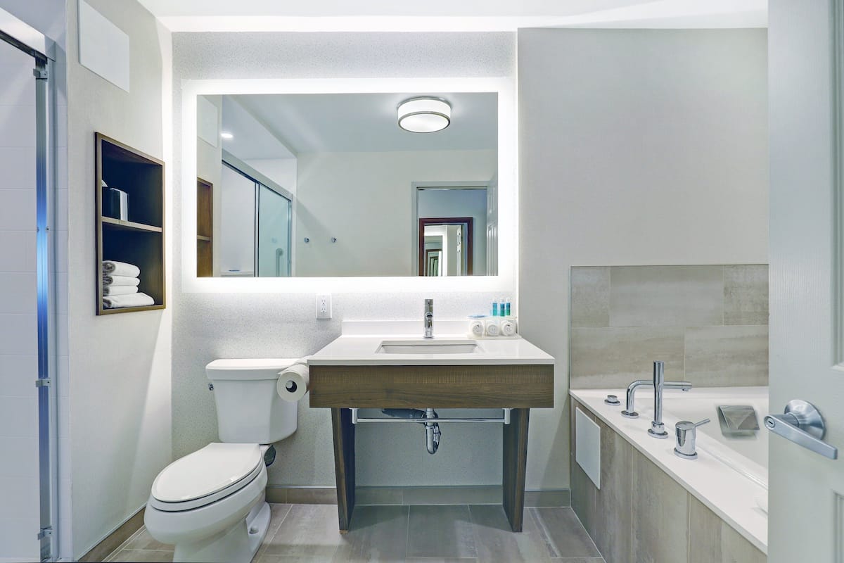 A modern bathroom with a toilet, sink, and shower.