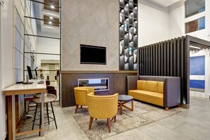 A modern interior with a flat-screen TV, a sofa, and a dining area with chairs. - Holiday Inn Express Whitby by IHG (Whitby)