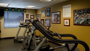 A fitness center with exercise equipment, framed pictures on the walls, and a sign indicating the center's name. - Holiday Inn Express Hotel & Suites Oxford by IHG (Oxford)