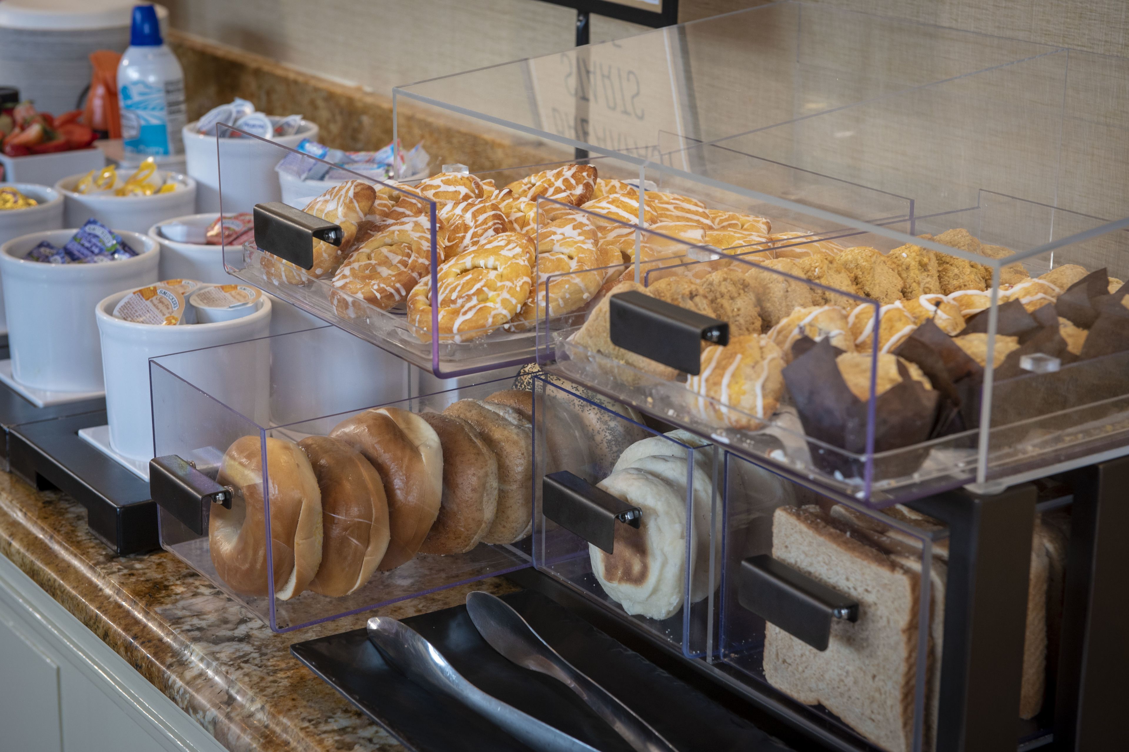 Un bufé de desayuno con diversos pasteles, sándwiches y bebidas.
