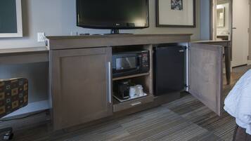 A hotel room with a flat-screen TV, a microwave, and a mini-fridge.