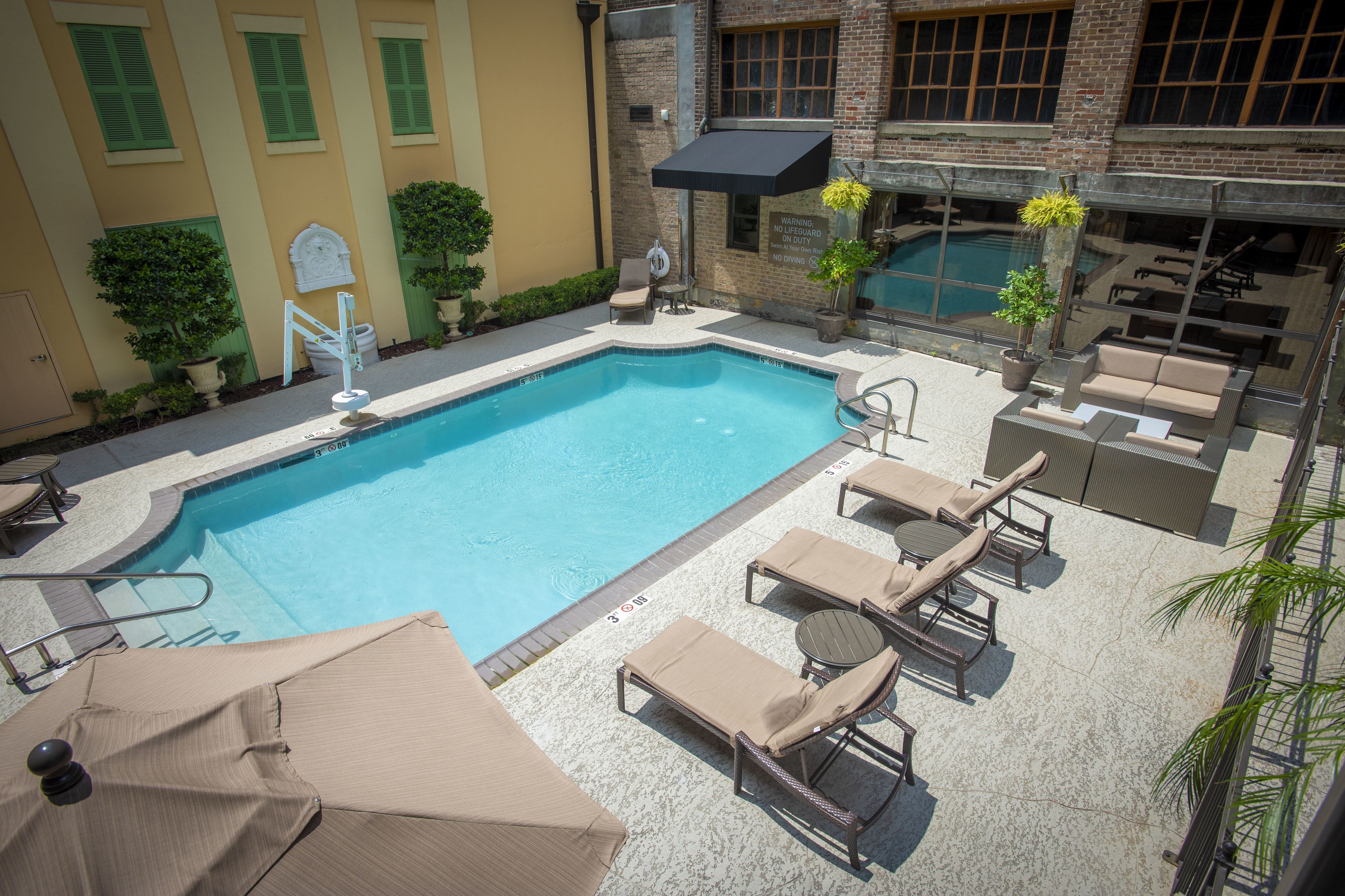 An outdoor swimming pool with lounge chairs and a covered seating area.