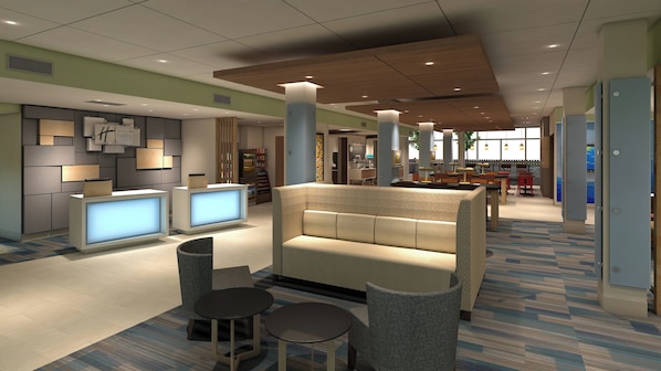 A hotel lobby with a reception desk, seating area, and a dining space.
