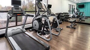 A gym with treadmills, elliptical machines, and weight benches.