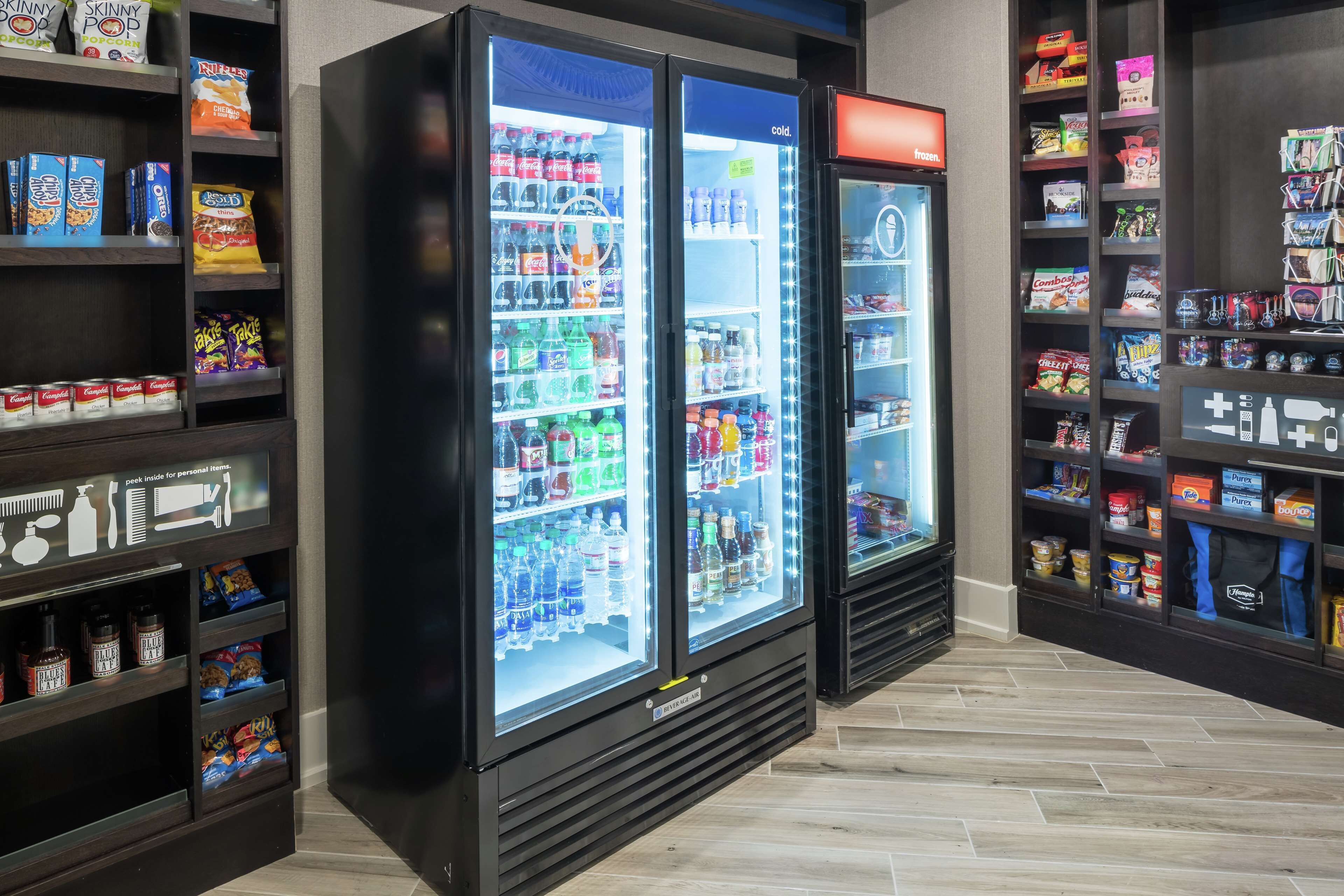 Un’area self-service con distributori automatici di bevande e snack, scaffali pieni di diverse bevande e snack.
