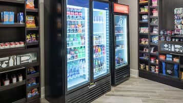 Un’area self-service con distributori automatici di bevande e snack, scaffali pieni di diverse bevande e snack.