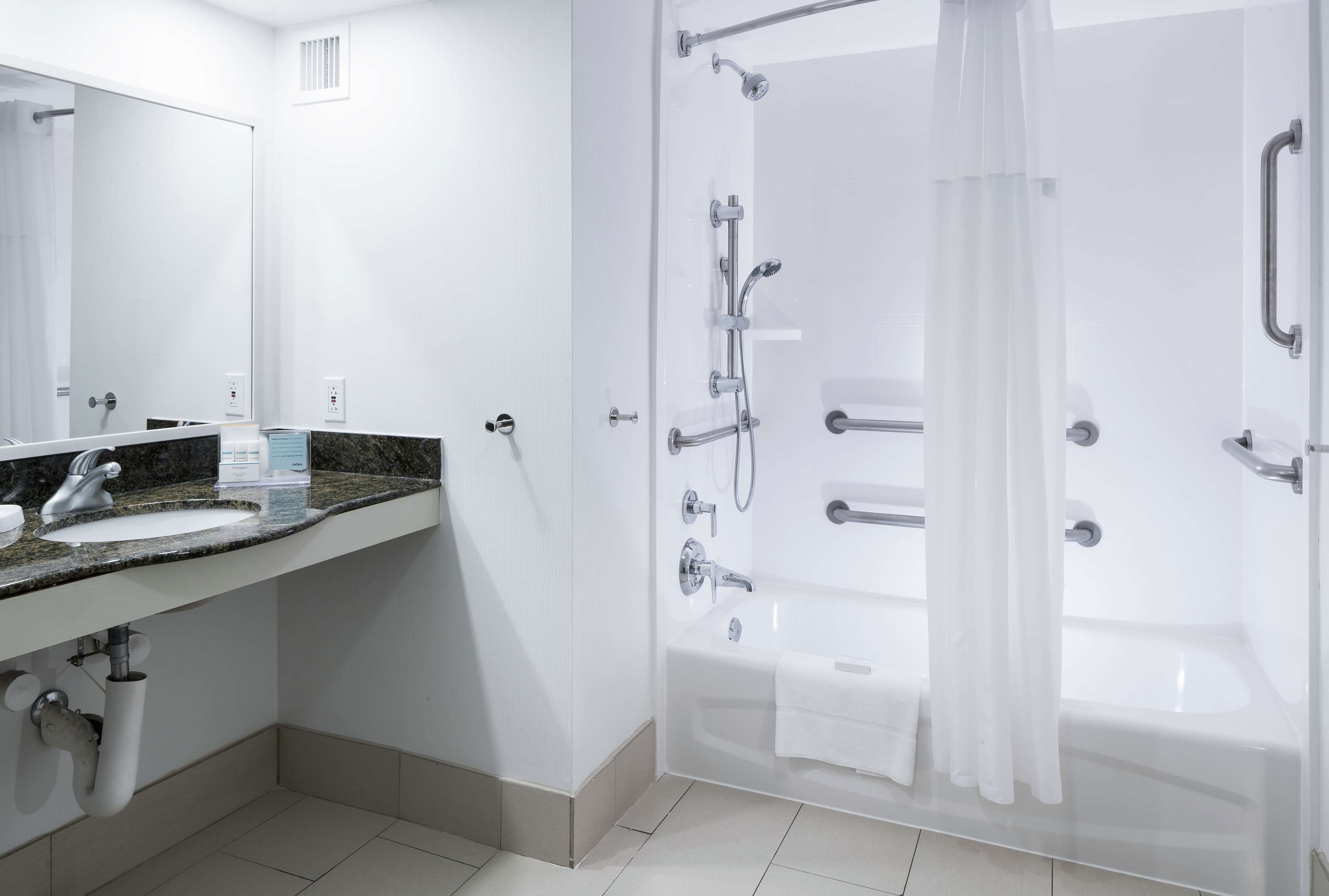 Une salle de bain moderne avec un lavabo, un miroir et un espace douche.