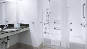 Une salle de bain moderne avec un lavabo, un miroir et un espace douche.
