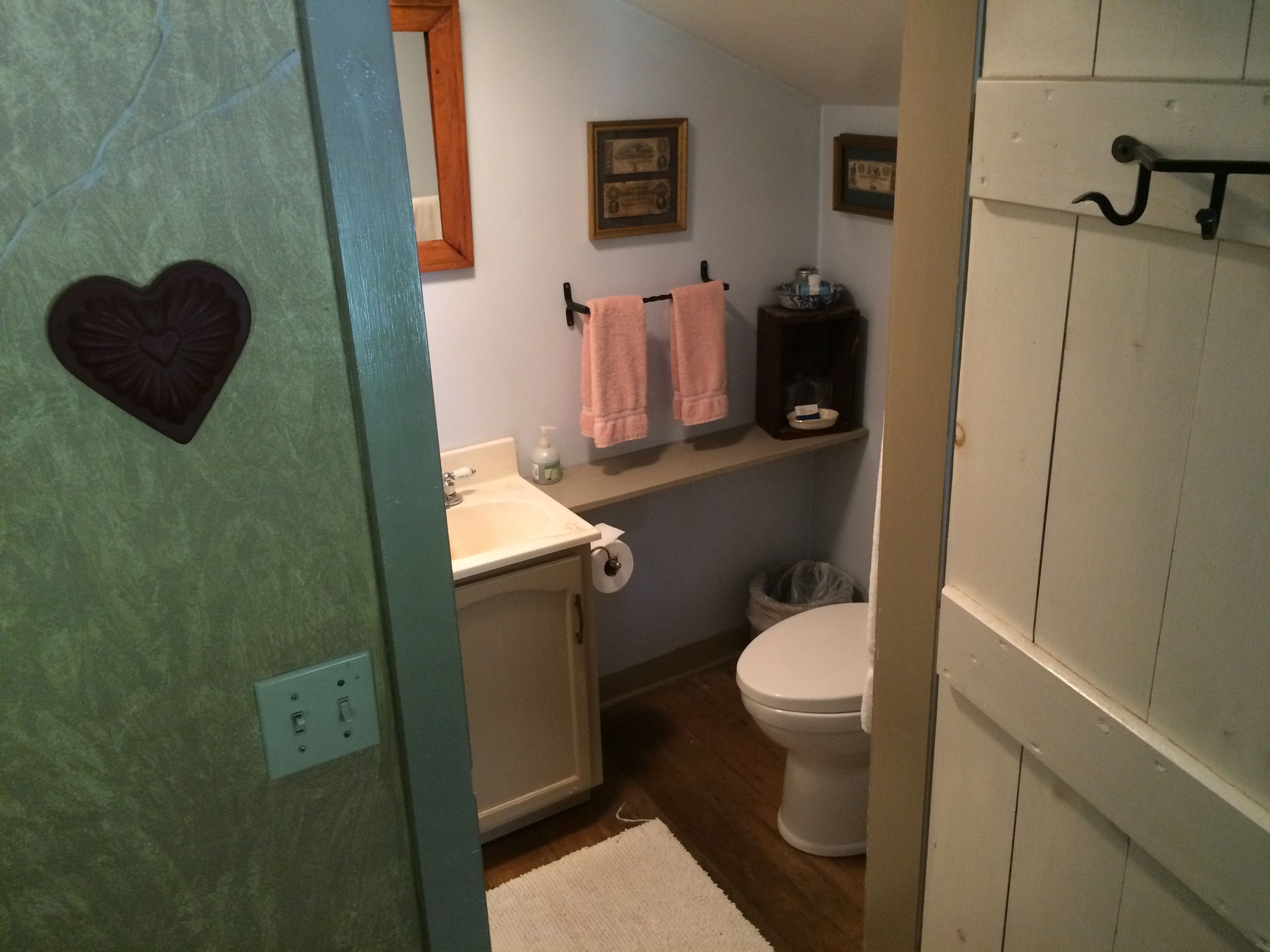 A bathroom with a sink, toilet, and a shelf with towels.