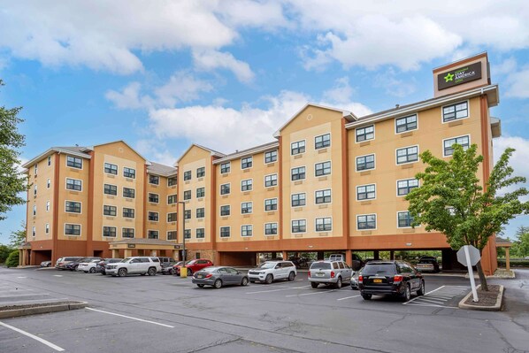 A multi-story hotel with a central courtyard and a parking lot. - Extended Stay America Suites Meadowlands Rutherford (Rutherford)