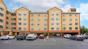 A multi-story hotel with a central lobby, parking lot, and a Stay America sign. - Extended Stay America Suites Meadowlands Rutherford (Rutherford)